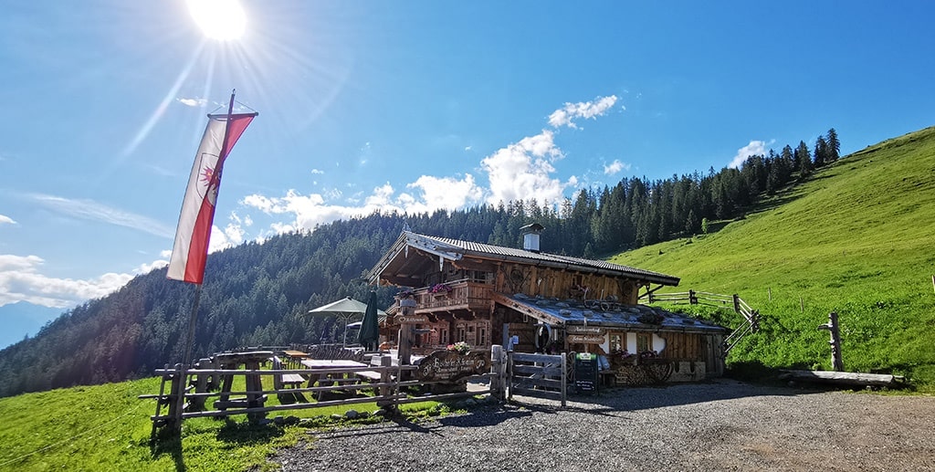 DMC in Alps – A scenic wooden mountain hut with a Tyrolean flag