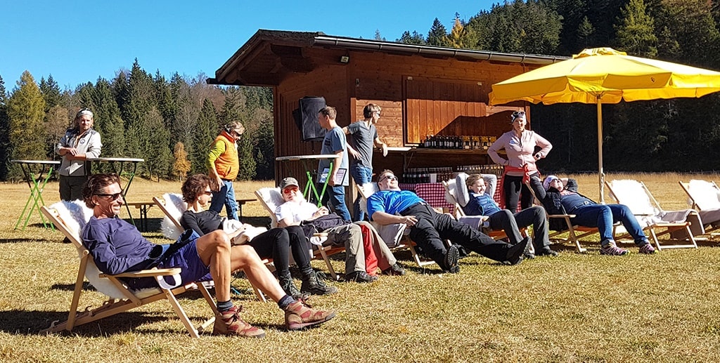 DMC in Alps – A group of tourists relaxing on deck chairs under a yellow parasol