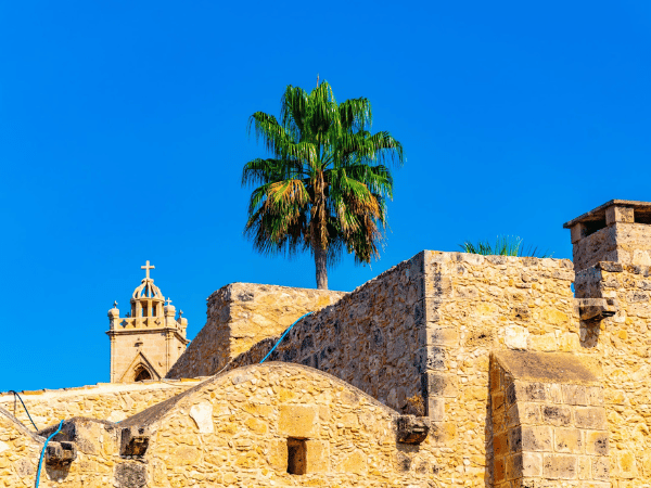 Historic Agia Napa Monastery with palm tree and stone architecture – DMC Cyprus