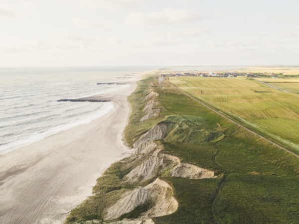 DMC in Denmark – Aerial view of Denmark’s coastline with sandy beaches, cliffs, and green fields, highlighting scenic travel spots.