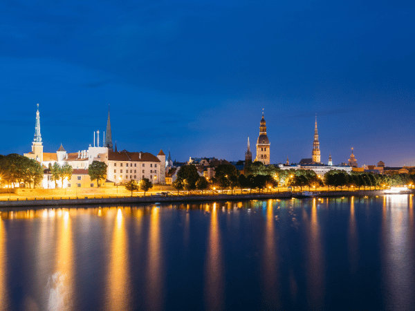 DMC in Latvia – Evening view of Riga’s skyline under a deep blue night sky.