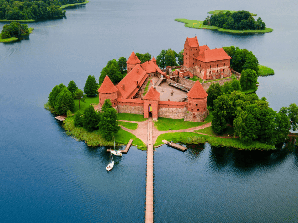 DMC in Lithuania – Aerial view of Trakai Castle surrounded by Lake Galvė, a top historical landmark.