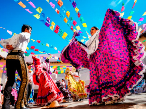Vibrant folk dancers in traditional Mexican attire perform a cultural dance, an authentic experience arranged by a DMC in Mexico.