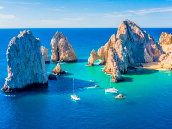 The iconic Arch of Cabo San Lucas, Mexico, with boats sailing nearby, a top destination to explore with a DMC in Mexico.