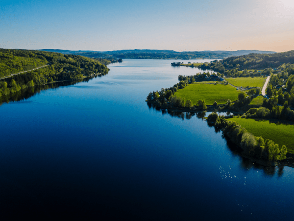 DMC in Sweden – Aerial view of a deep blue lake surrounded by forests and farmland.